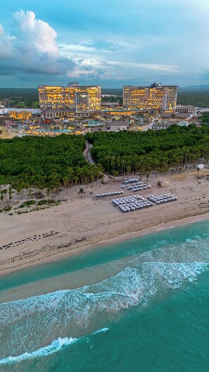 A resort with multiple buildings, a beach with sun loungers, and a pool area. - Moon Palace The Grand - Punta Cana - All Inclusive (Punta Cana)