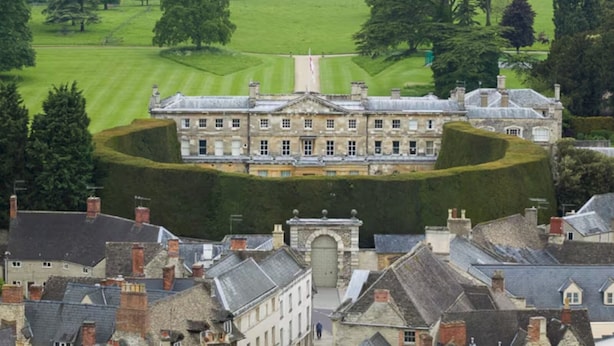 A large, historic building with a symmetrical facade, surrounded by a well-manicured lawn and trees. - Studio37 - A cosy, stylish central hideaway | Pass the Keys (Cirencester)