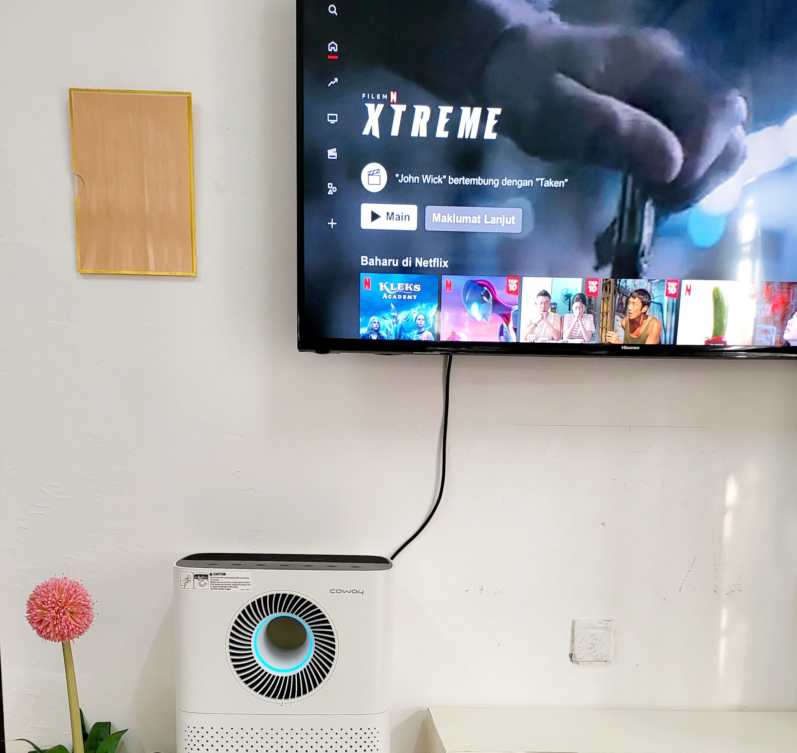 Un téléviseur fixé au mur affiche l’interface de Netflix, avec le titre « Xtreme » et une sélection de films.