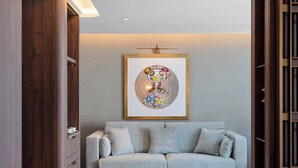 Ein modernes Wohnzimmer mit einer Couch, einem Couchtisch und einem gerahmten Kunstwerk an der Wand.