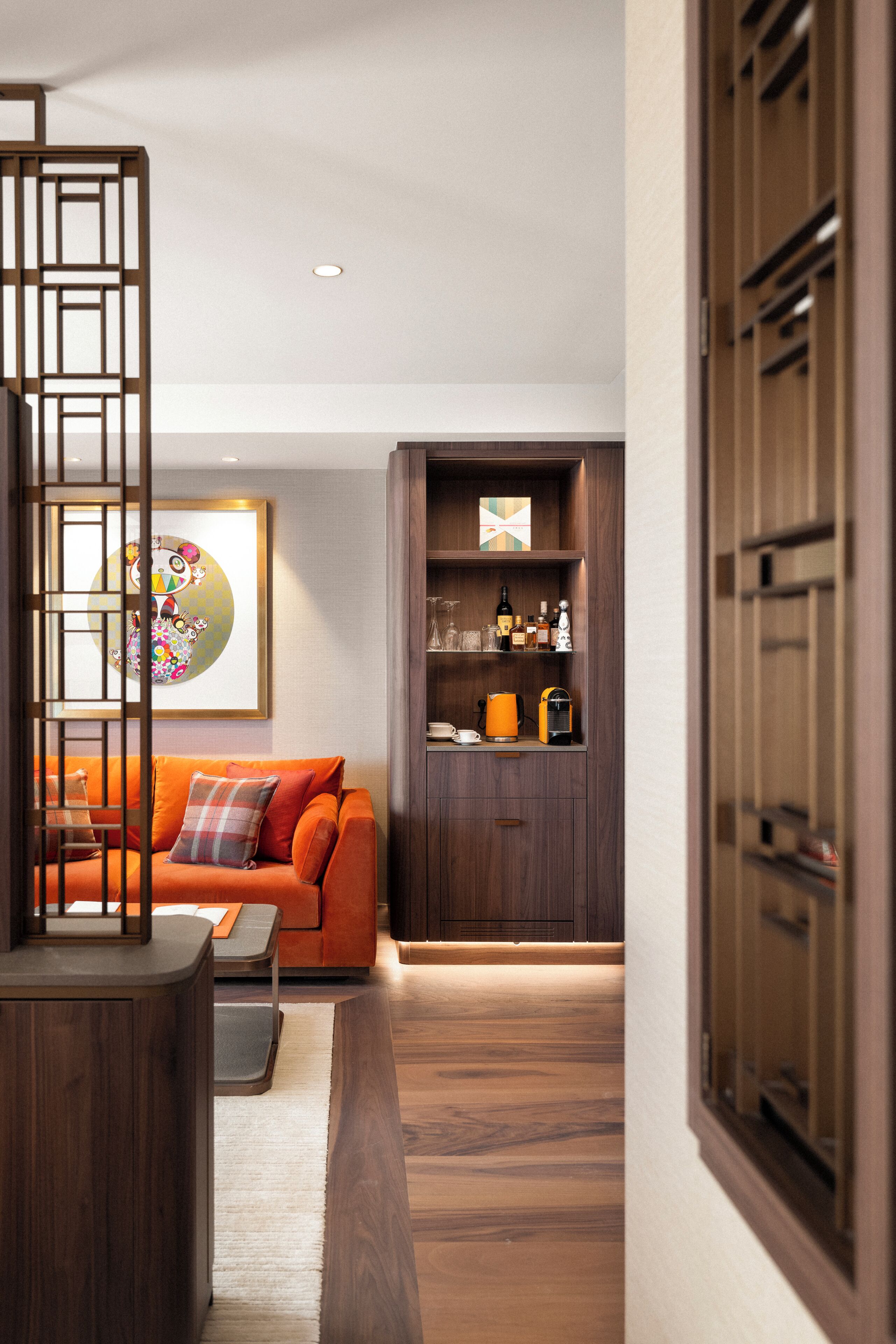 A modern living room with a sofa, coffee table, and a wooden cabinet with shelves.