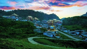 A traditional village with tiered buildings and a prominent golden stupa. - Luqu Langmusi Hongshan Holiday Hotel (Luqu)