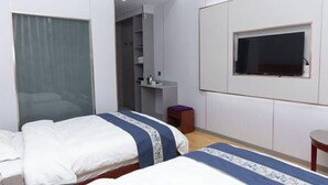 A hotel room with two beds, a TV, a wardrobe, and a bathroom visible through an open door. - Luqu Langmusi Hongshan Holiday Hotel (Luqu)