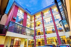 Ein mehrstöckiges Gebäude mit großen Fenstern und einer rot-weißen Fassade.