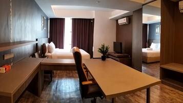 A hotel room with a bed, a desk, a chair, a television, and a small table.