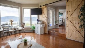 Ein Zimmer mit Essbereich, Küche und einer Schiebetür im Scheunenstil.