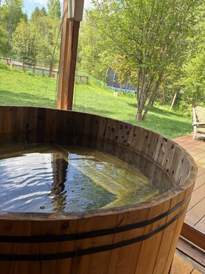 A wooden hot tub with a view of a grassy yard and trees. - Steamboat Downtown Retreat (Steamboat Springs)