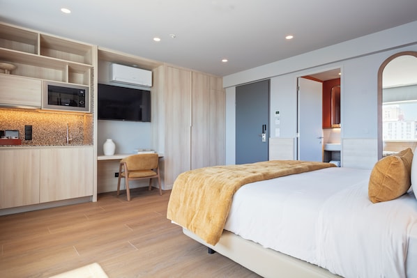A modern hotel room with a bed, a desk, and a kitchenette. - Hotel Acta Moa (Lisbon)