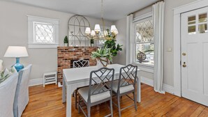 A dining area with a brick fireplace, white table, and grey chairs. - 3 bed/2 BA house in great Augusta area w/Wi-Fi, AC, and many restaurants nearby (Augusta)