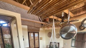 A kitchen with a hanging pot rack, a stove, and a window with a view. - Hotel Artesanal  (San Francisco)