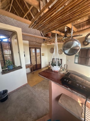 Una cocina con un colgador para ollas, una estufa y una ventana con vistas.