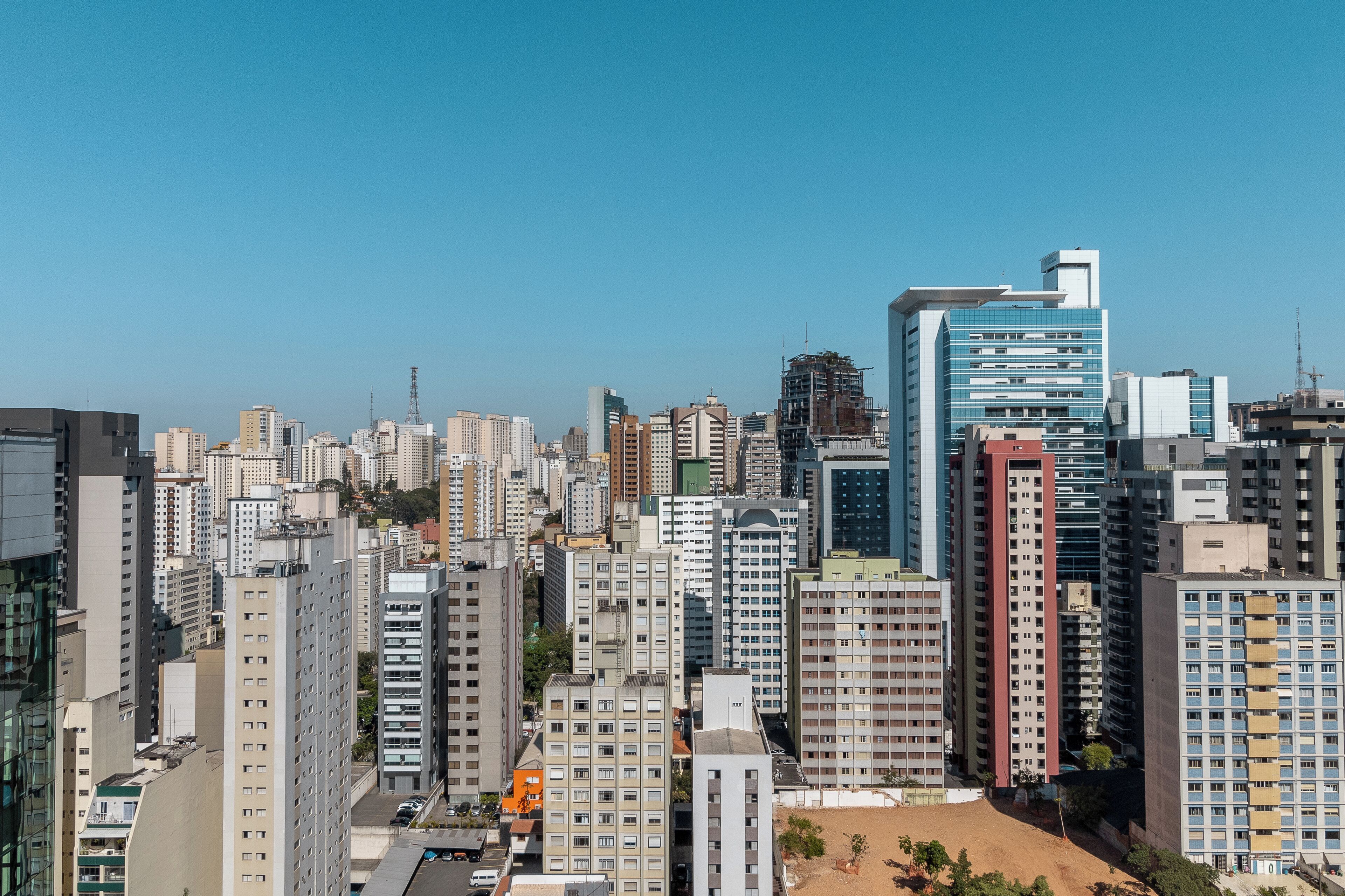 A cityscape with high-rise buildings, including a prominent blue glass building.