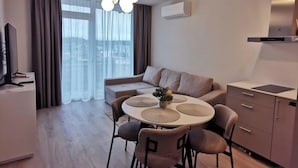 Un salon moderne avec une table de salle à manger ronde, un canapé et un coin cuisine.