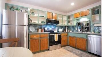 A kitchen with wooden cabinets, a stainless steel refrigerator, and a microwave.
