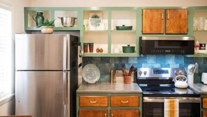 A kitchen with a stainless steel refrigerator, wooden cabinets, a microwave, and a stove. - The Eden, 1BR Queen Duplex by Velvet Ditch Villas (Oxford)