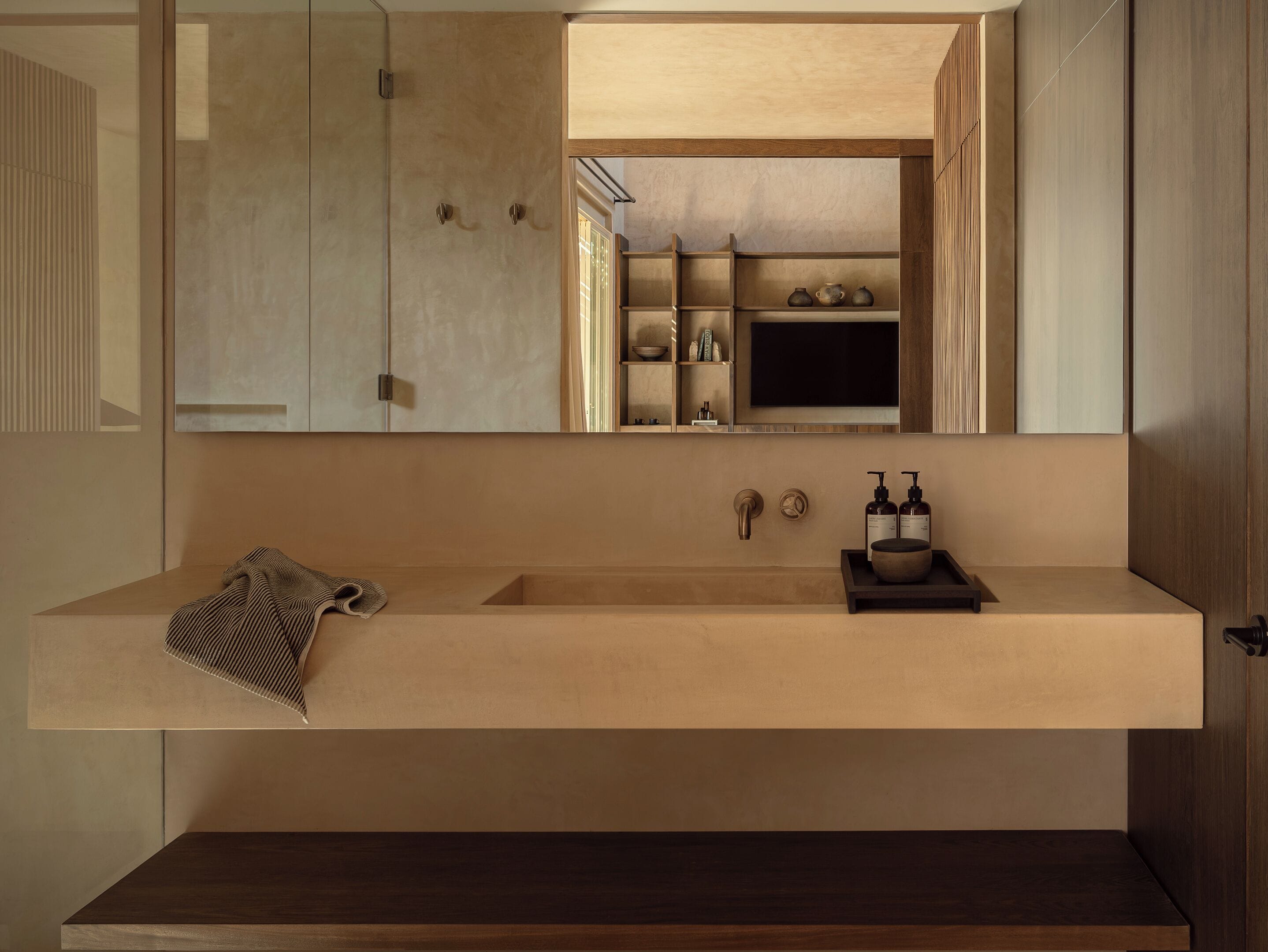 Un baño moderno con un espejo grande, un lavabo color beige y un mueble de tocador de madera.
