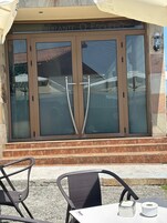 Un restaurante con un amplio escaparate de vidrio y un cartel que dice 'AURANTE O ESQUERTO'.