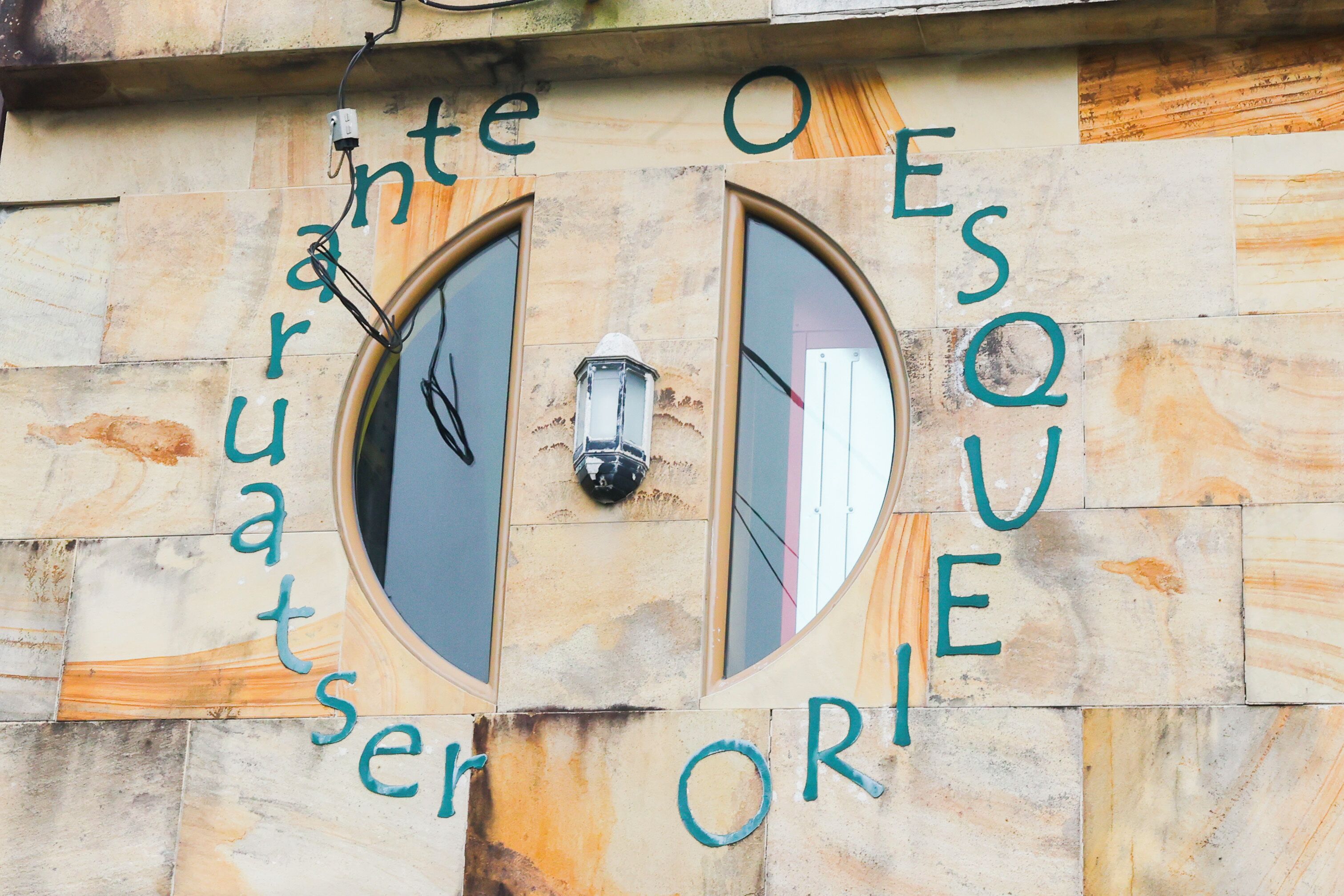 A building facade with two arched windows and the words "intention" and "esque" written across them.