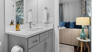 Un baño moderno con un espejo grande, dos lavamanos, un inodoro y un mueble de tocador con cajones.