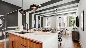 A modern kitchen with a central island, wooden cabinets, and pendant lighting. - 2 Stunning Homes in Nashville | Downtown Views! (Nashville)