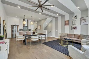 Un vaste espace de vie comprenant une table à manger, un canapé et un escalier menant à l’étage supérieur.