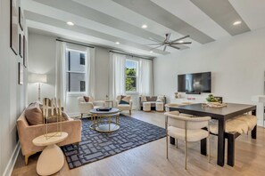 Relax and unwind in this bright, open-concept living room featuring soaring ceilings, modern decor, and plenty of space for the whole group.