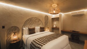 Un dormitorio con cama, lámparas de noche, una lámpara colgante y un equipo de aire acondicionado.