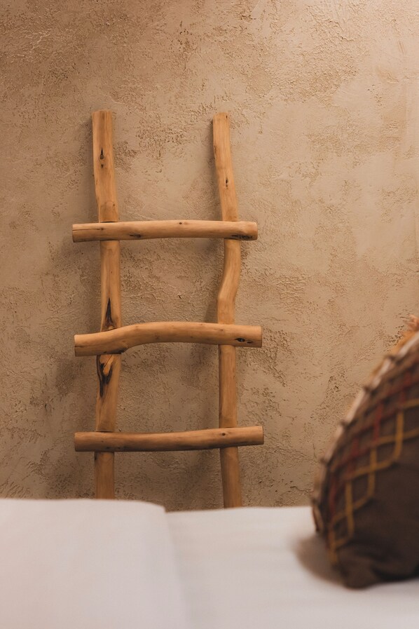Une échelle en bois appuyée contre un mur à texture.
