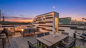 An outdoor patio area with a dining table, chairs, and a sofa.