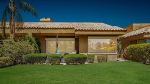 A modern house with a tiled roof, large windows, and a well-maintained lawn. - Prestigious Fairway Living – Luxe 2BR on 7th Hole, Mission Hills (Rancho Mirage)