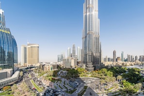 A cityscape with modern skyscrapers, a roundabout with palm trees, and a clear blue sky. - Burj Vista - Prime Downtown Dubai (Dubai)