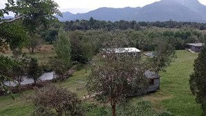A rural property with a house surrounded by trees and a small pond. - Untamed Refuge in Rio Puelo (Arrayan) (Los Lagos)