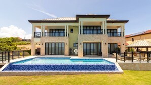 Une maison à deux étages avec une piscine située dans le jardin avant.