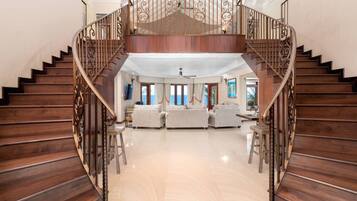 A spacious living area with a wooden staircase leading to an upper floor.