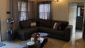 A living room with a sectional sofa, a glass coffee table, and a lamp. - 3 King Beds Drax Hall Pool Gym Gated Full Air Con (Ocho Rios)