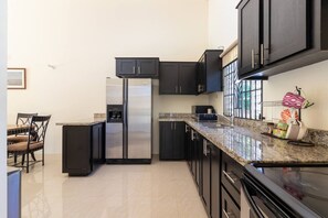 A modern kitchen with dark cabinets, stainless steel appliances, and granite countertops. - Private Pool Draxhall Gated Gym Tennis Full AC (St. Ann's Bay)