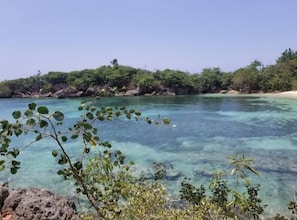A clear view of a beach with turquoise water, surrounded by lush greenery and rocky outcrops. - Draxhall Beach Access Gated Community Full Air Con (St. Ann's Bay)
