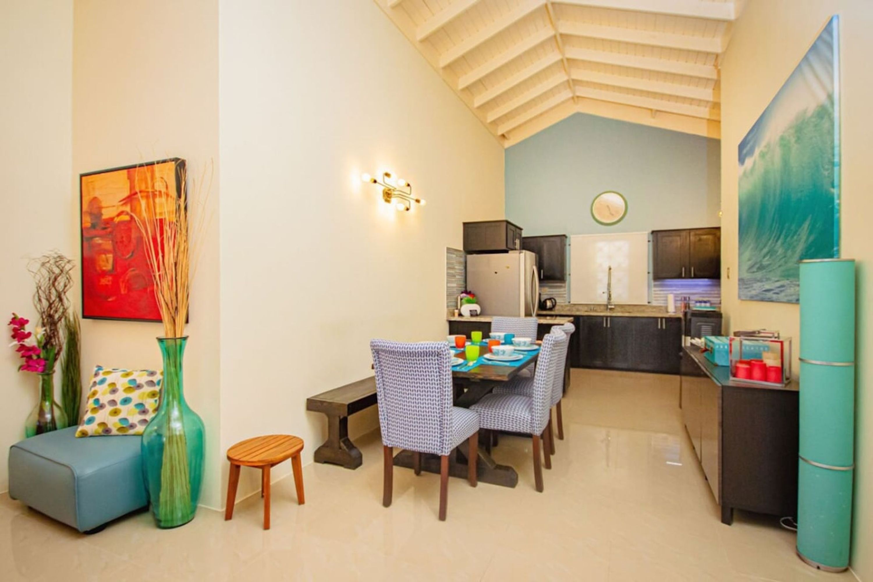 A compact living space with a dining area, kitchenette, and a loft bedroom.