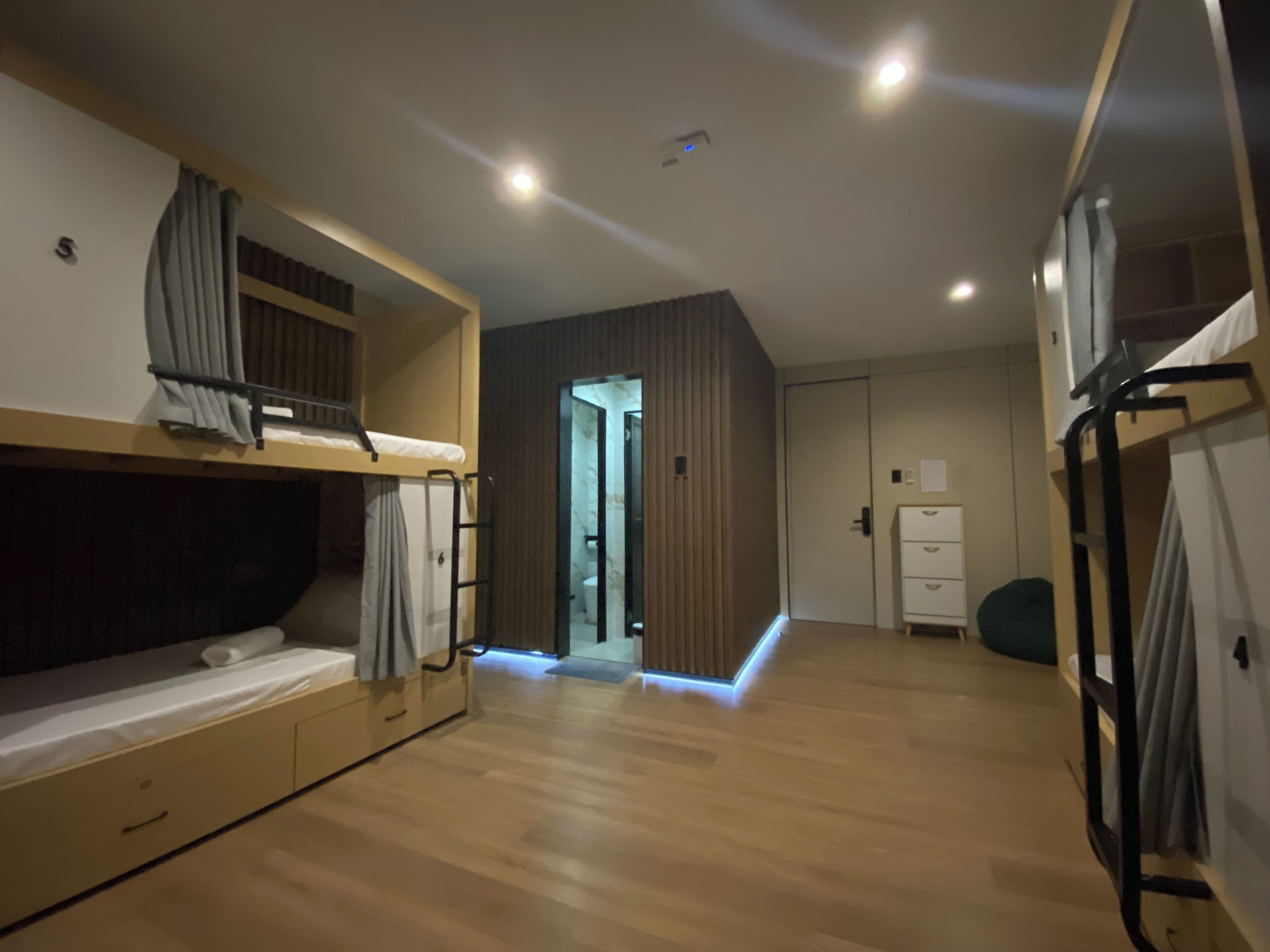 A room with bunk beds, a desk, and a wardrobe.