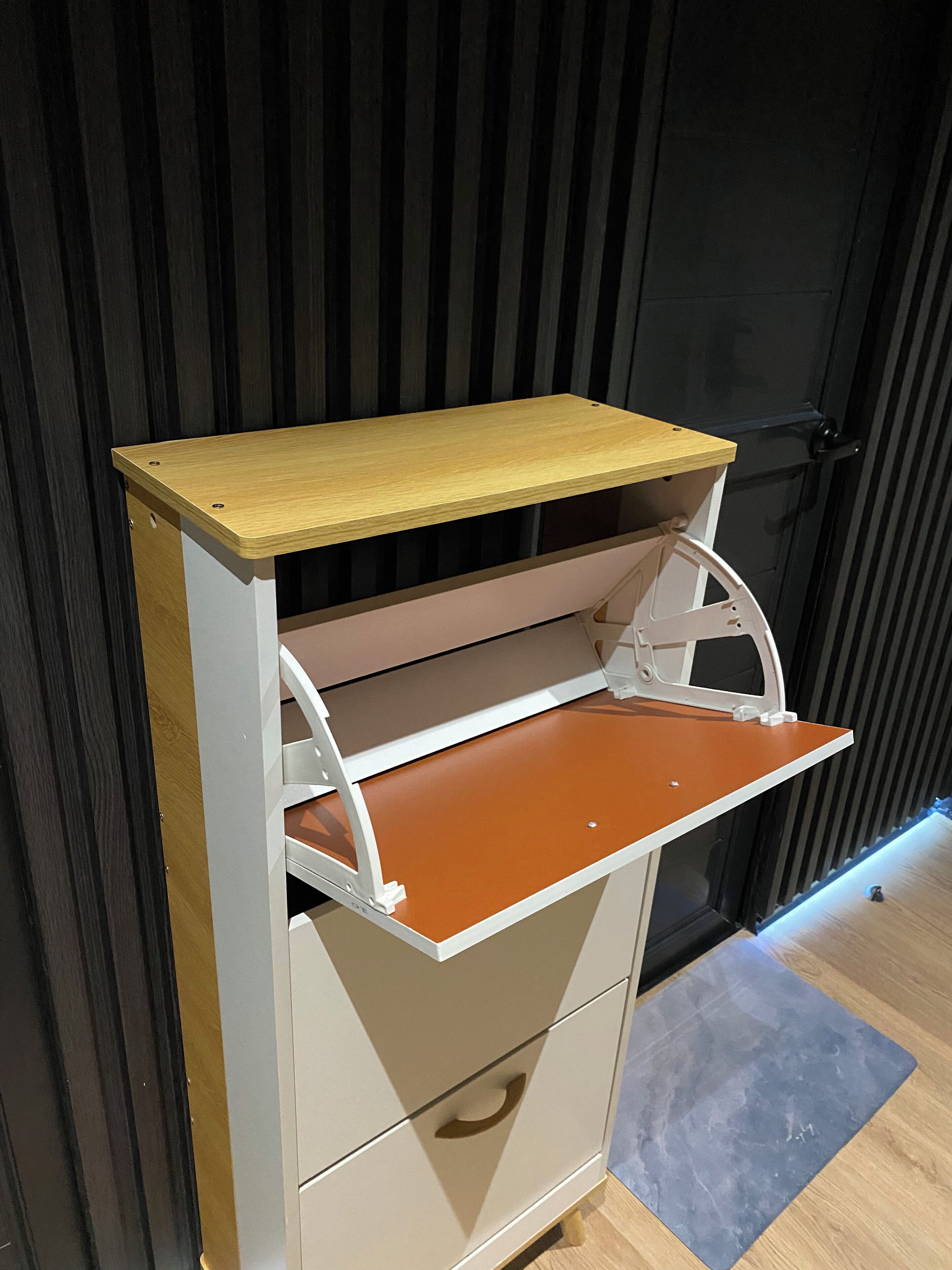 Uma kitchenette compacta com bancada de madeira, pia branca e uma gaveta.