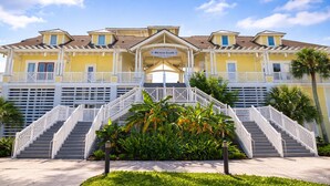 Un hôtel à plusieurs étages, doté d’une entrée principale, de balcons et d’une enseigne indiquant « Beach Club ».