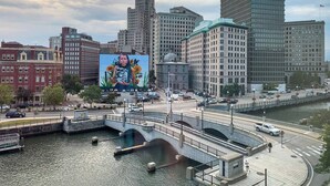 A cityscape with a prominent building featuring a large mural.