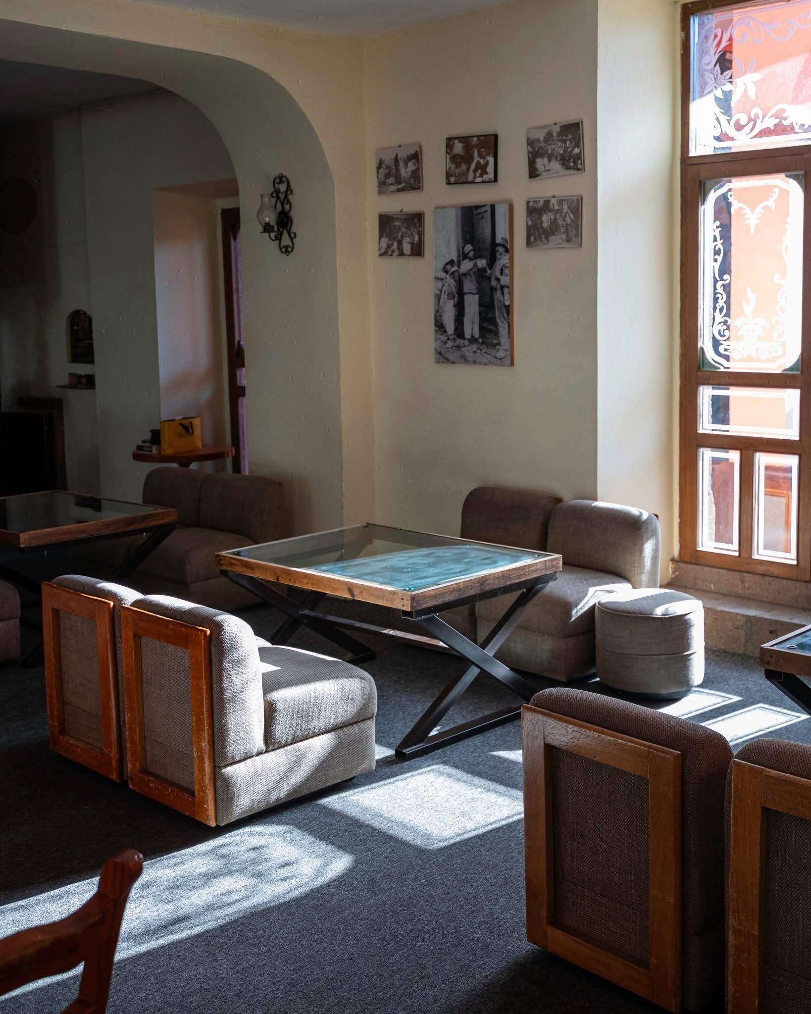 A living room with a sofa, armchairs, a coffee table, and a television.