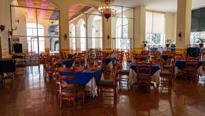 A large dining hall with multiple tables and chairs, high ceilings, and large windows. - Hotel Hacienda La Muralla (Amealco)