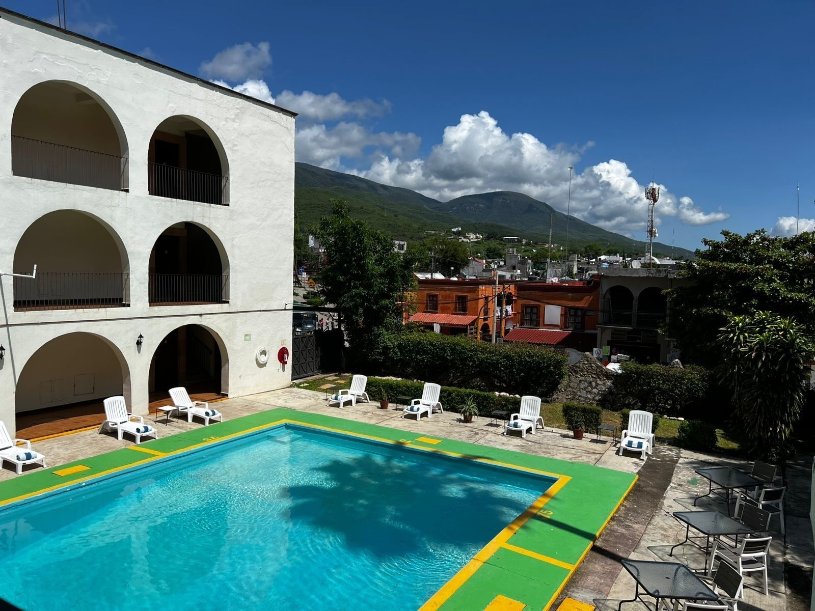 Una piscina al aire libre, sillones reclinables de piscina