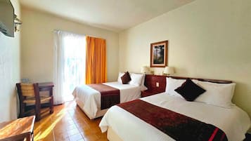 Una habitación de hotel con dos camas, un escritorio y una silla.