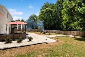 A backyard with a barbecue area, outdoor furniture, and a covered seating area.