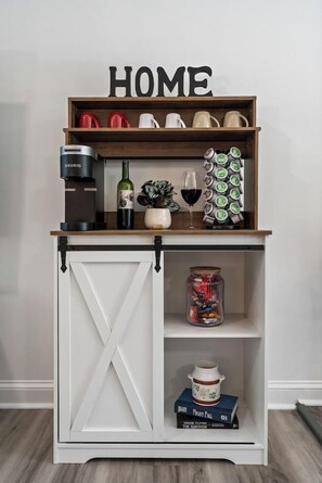 A storage unit with a 'HOME' sign, containing various kitchen items and a coffee maker.