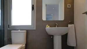 Une salle de bain avec des toilettes, un lavabo et un miroir.