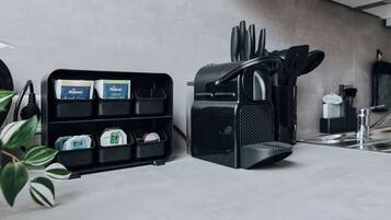 A kitchen counter with a coffee machine, a knife holder, and a shelf with packaged goods.